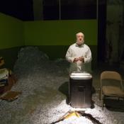 A man in a room with a shredder, surrounded by shredded paper