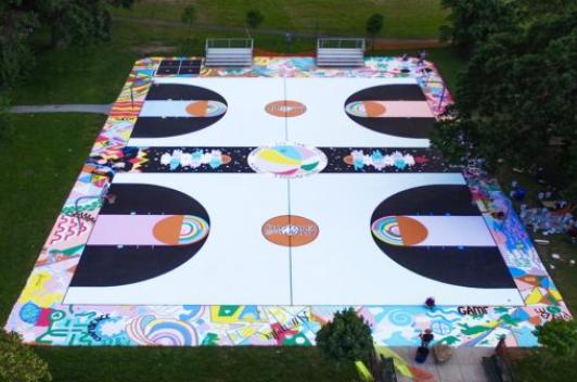 Sky view of a basketball court that has been painted with various designs and colors.