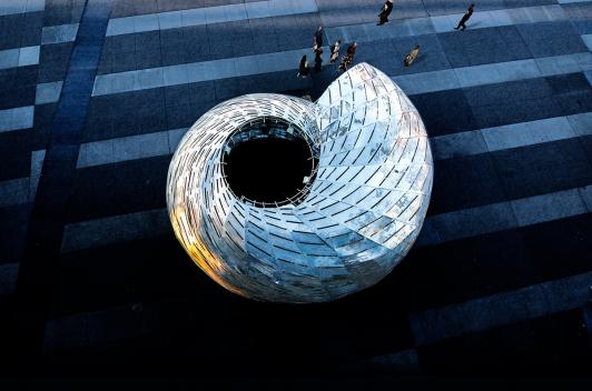 An overhead shot of a metal structure that looks like a seashell.