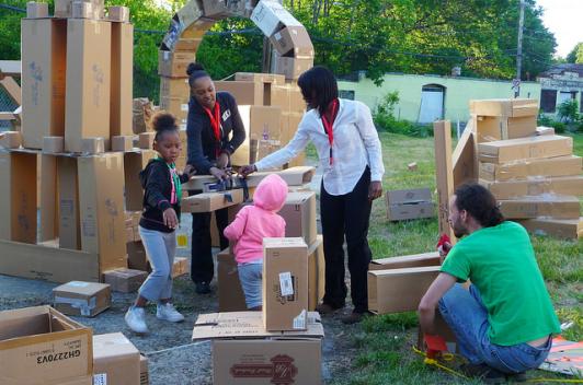 Group of various ages playing and building with cardboard boxes