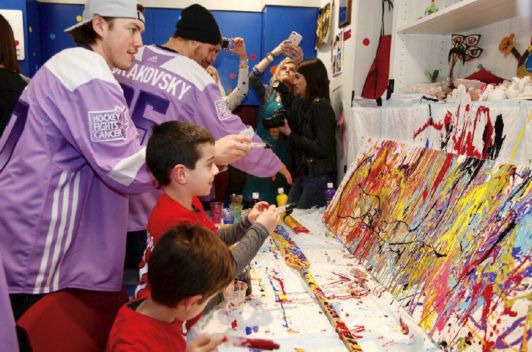 People in sports jackets with children painting on canvas