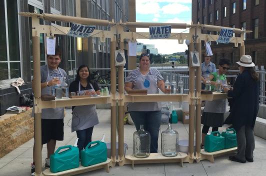 A bar, set up on the middle of a sidewalk, giving water samples. 