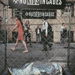A small cage made out of fencing holds a reflective blanket, covering what looks like a body. 