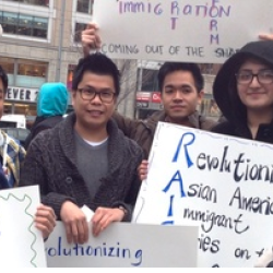 Group of smiling people holding signs about the civil rights of undocumented Asians in American
