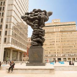 Sculpture in the middle of a downtown area. Sculpture is dark grey and features various body parts