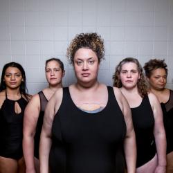 7 swimmers in black swimsuits in a triangle formation.
