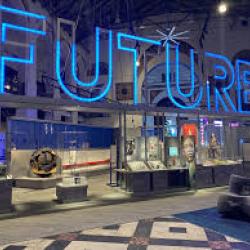 A room filled with various technology displays and a the word FUTURE in blue neon lights