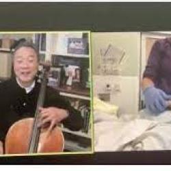 Yo Yo Ma on the left playing cello virtually for the patient on the right screen