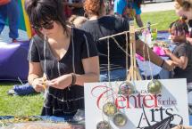 Person at a craft table with a sign saying Center for the Arts