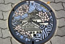 Image of a manhole in Japan and the manhole has the design of a castle on it